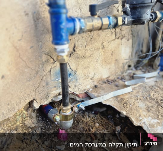 צנרת מים עם ברזים וחיבורים בקיר חיצוני